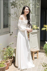 Off-shoulder long sleeve gown in flowing silk with elegant A-line silhouette